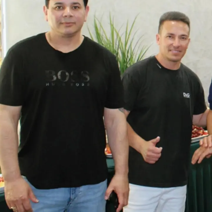 Two men from the USA Countertops team, smiling, at an evening event